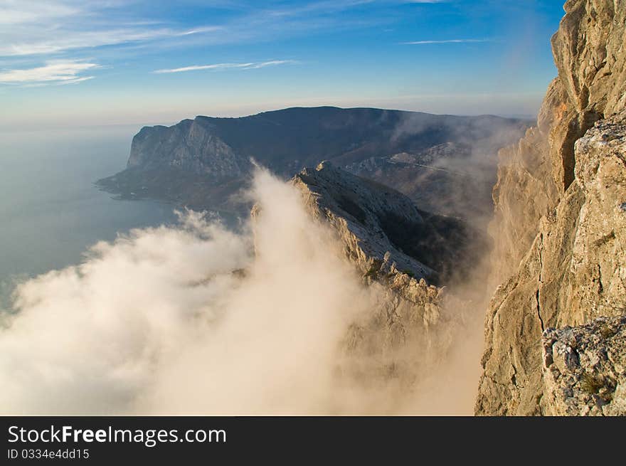 Scenic ridge facing the sea. Clouds rise to the top of the mountain. Scenic ridge facing the sea. Clouds rise to the top of the mountain