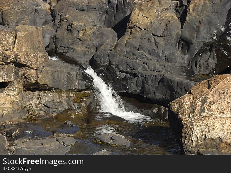 Water running through a rock forming a waterfall