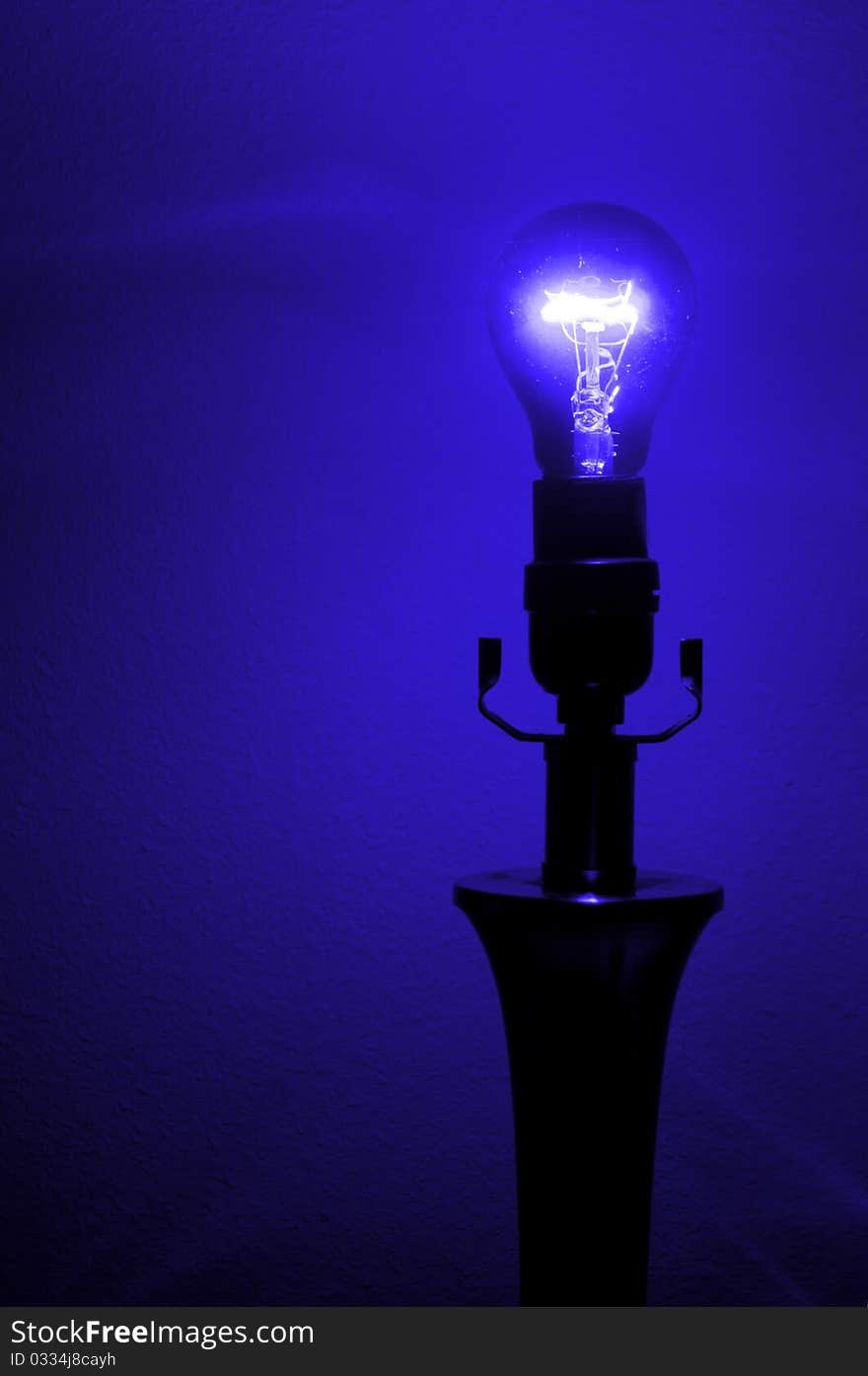 An ultraviolet purple black light against a wall in a lamp. An ultraviolet purple black light against a wall in a lamp.