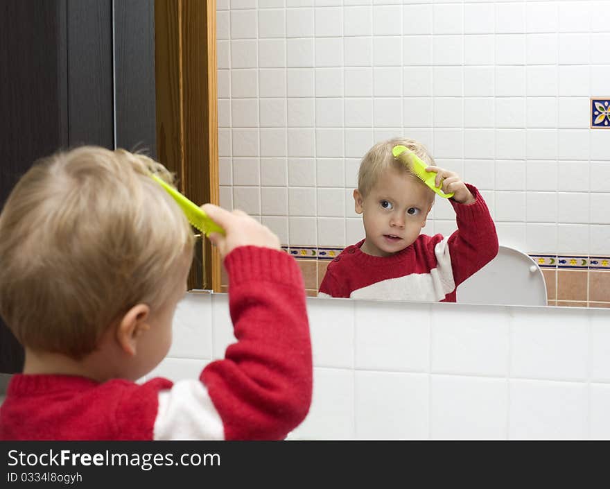 The little boy combs hair