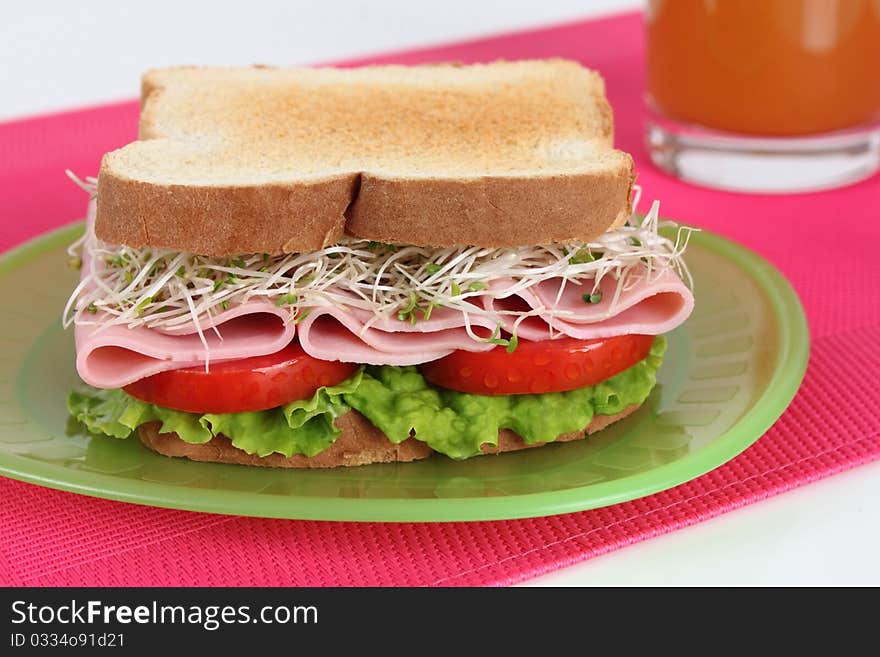 Ham sandwich with alfalfa, tomato and lettuce