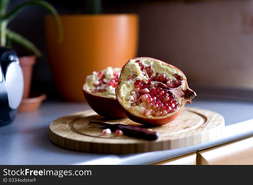 Two halves of pomegranate on the cutting board