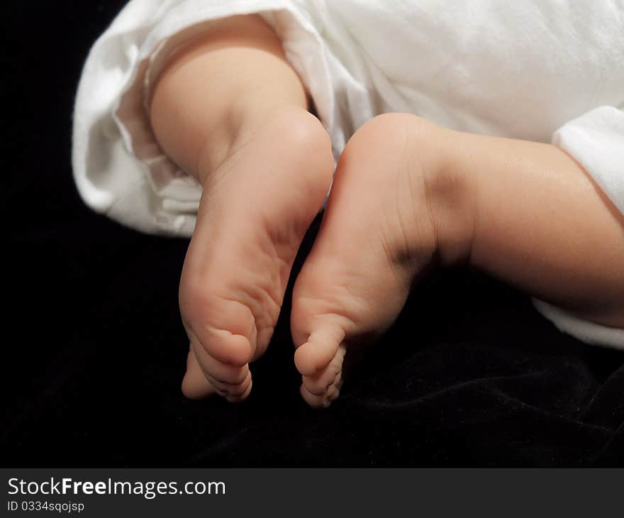 Little babies feet on a black isolated background