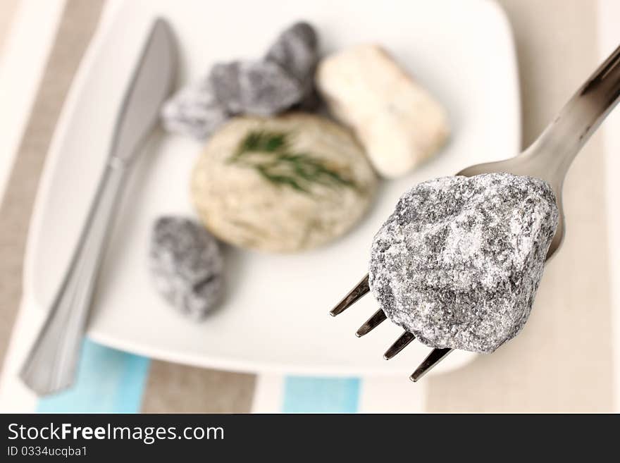 White plate with stones and fork