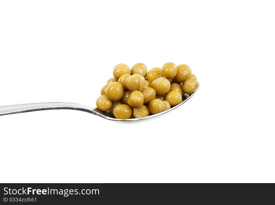 Spoon with green peas on a white background