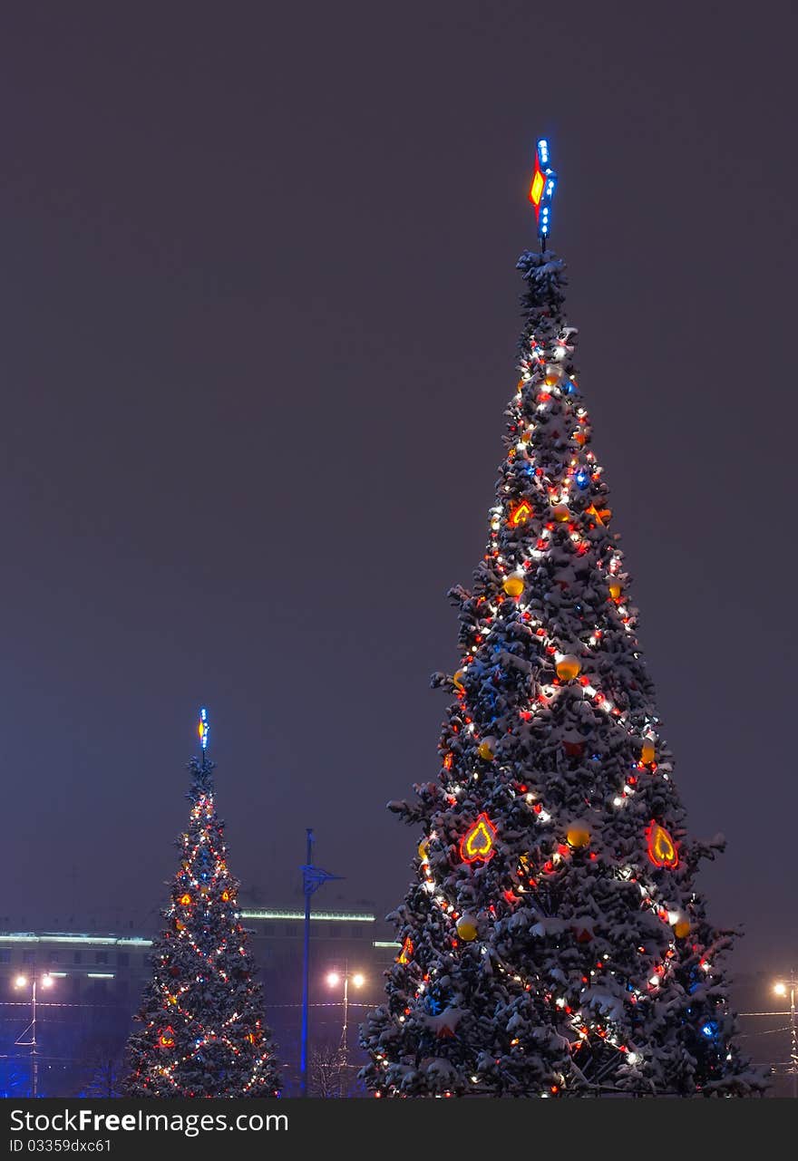 Christmas tree decorated with show on branches and garlands of night