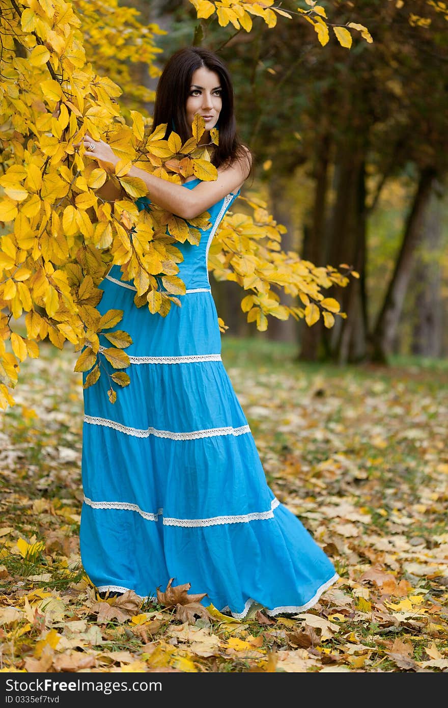 Woman with yellow leaves in autumn