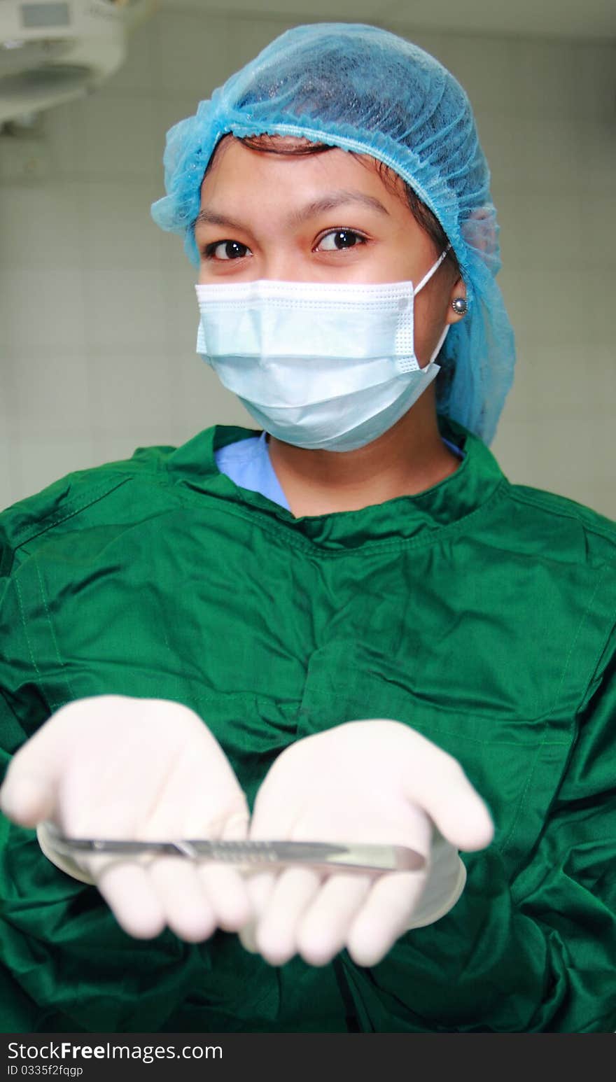 Asian nurse showing a surgical knife. Asian nurse showing a surgical knife