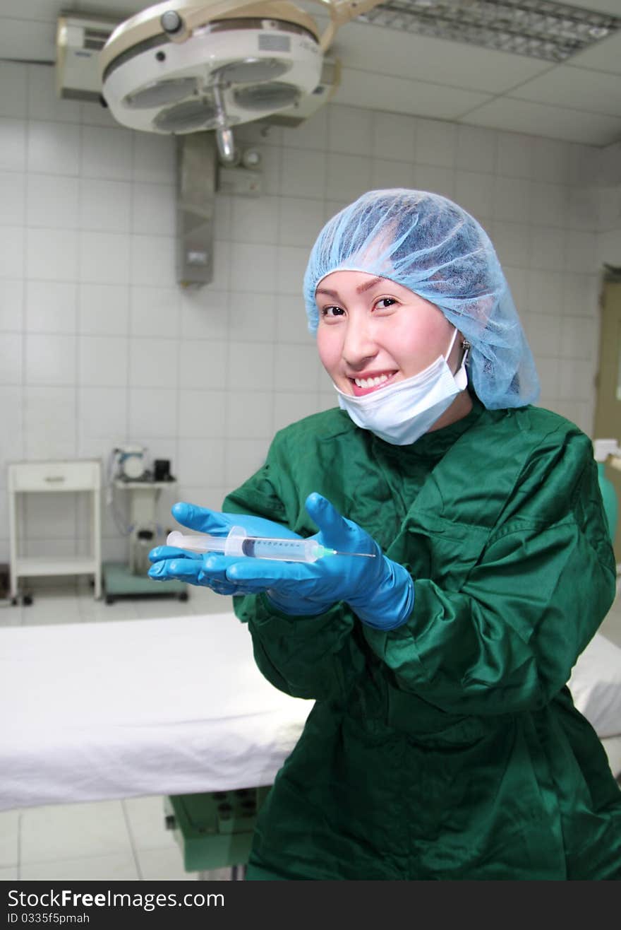 Operating room nurse showing a syringe. Operating room nurse showing a syringe