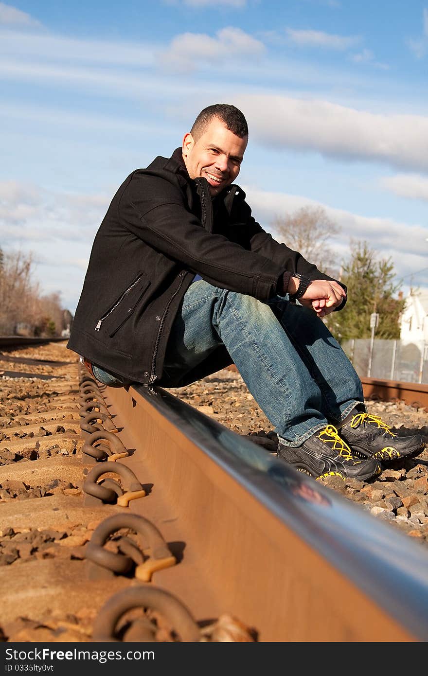 This guy is ready for vacation. He is waiting for his train at the train station.