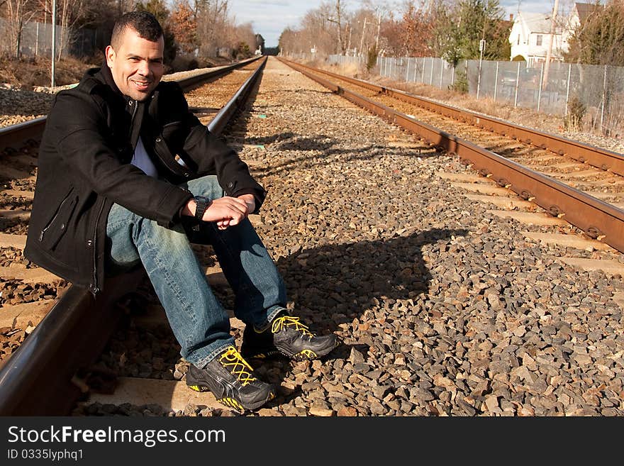 Guy on vacation waiting for his train at the train station.