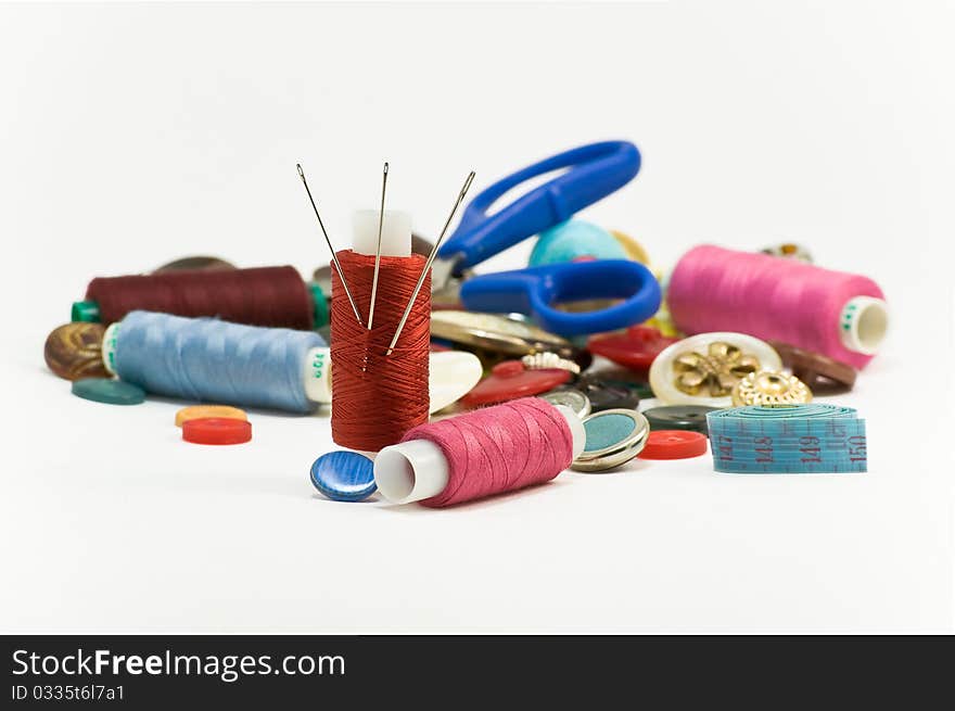 Threads,needles and buttons on white background. Threads,needles and buttons on white background