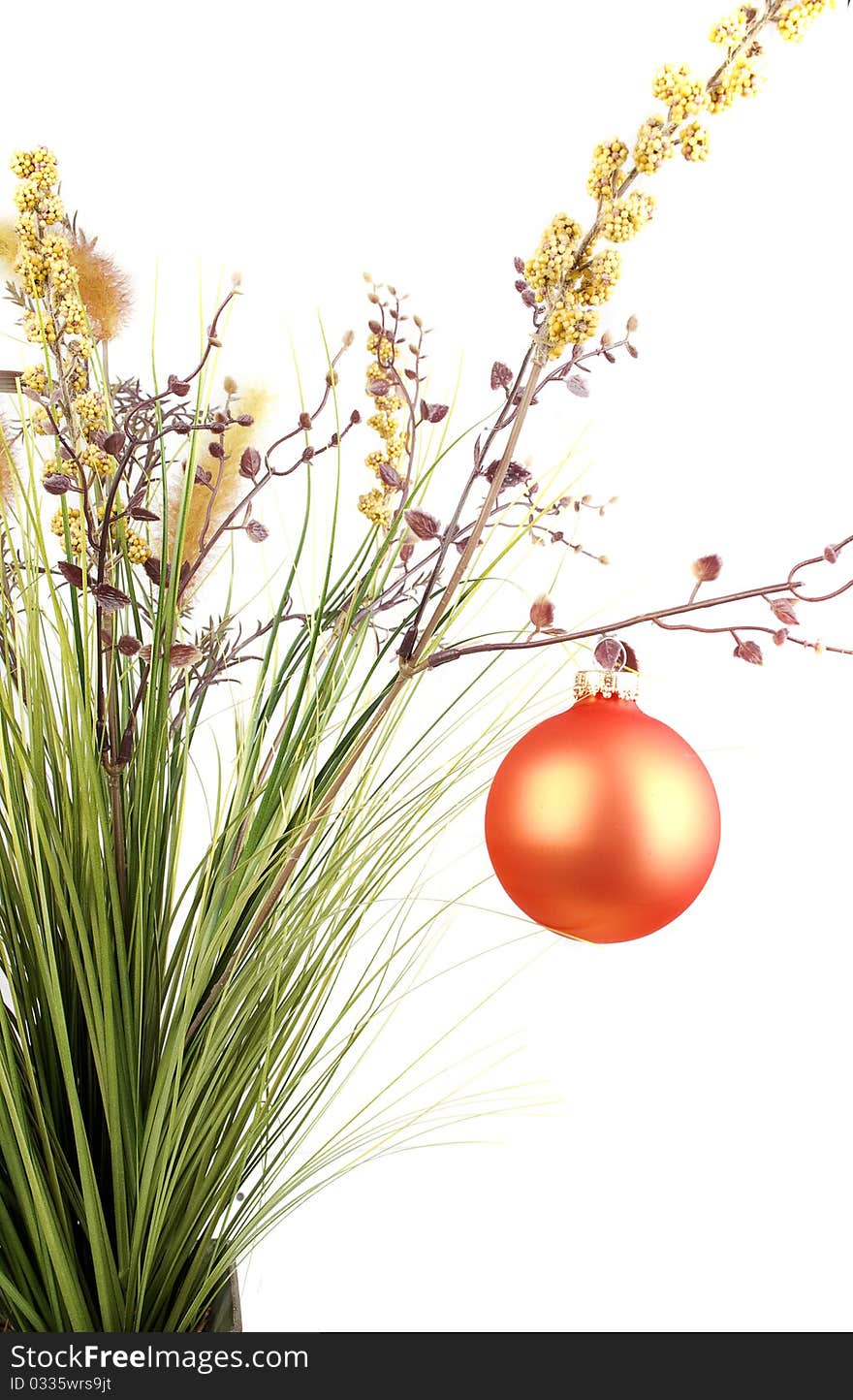 Bunch with artificial grass and blue flowers in metal vase decorated with Christmas orange balls isolated on the white background. Bunch with artificial grass and blue flowers in metal vase decorated with Christmas orange balls isolated on the white background.