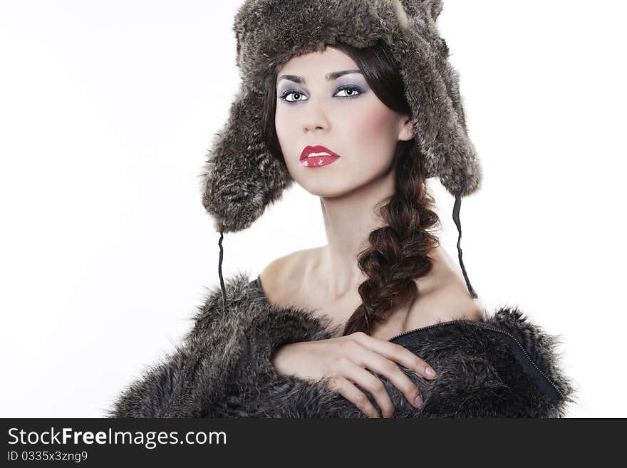 Portrait of young beautiful woman in a fur coat and hat