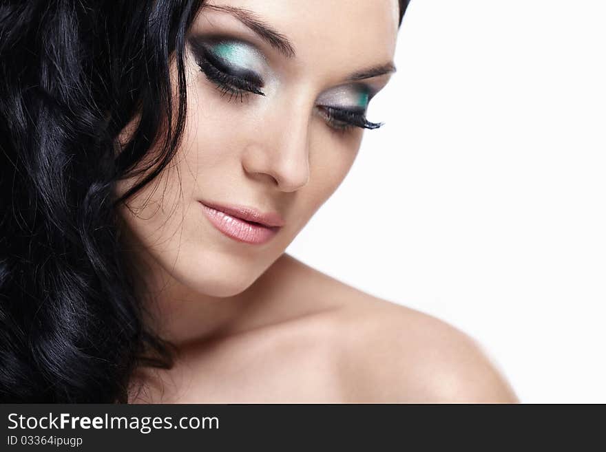 Portrait of a young girl with make-up and laying on a white background