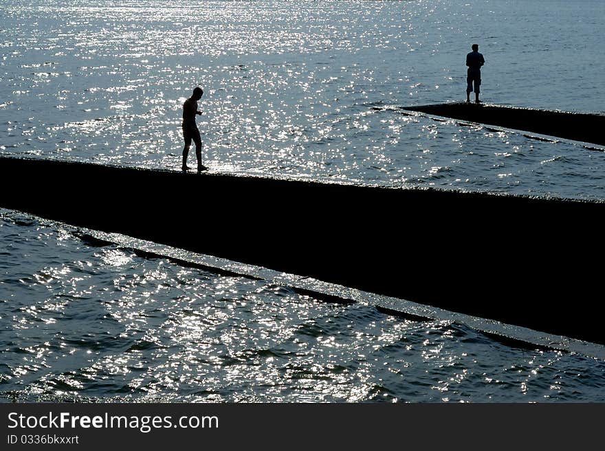 Human Silhouettes At The Dyke