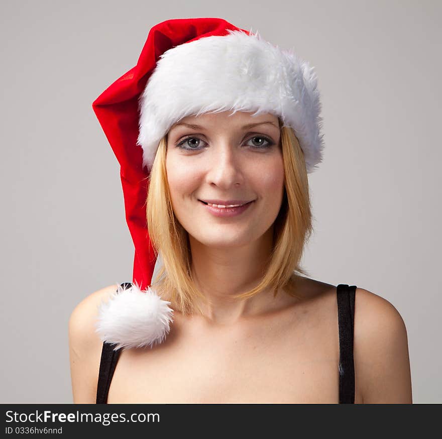 Christmas girl portrait in santa hat on grey background