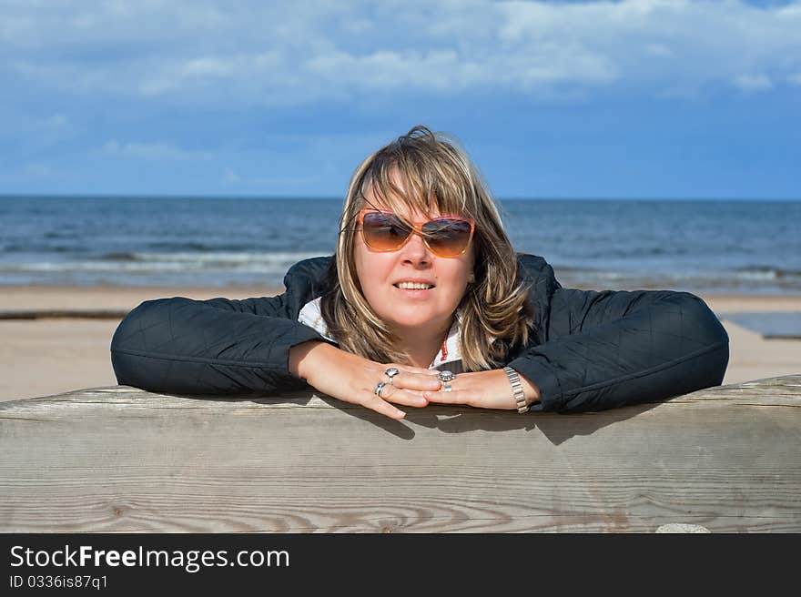 Portrait of mature woman in sunglasses relaxing at the Baltic sea in autumn day. Portrait of mature woman in sunglasses relaxing at the Baltic sea in autumn day.