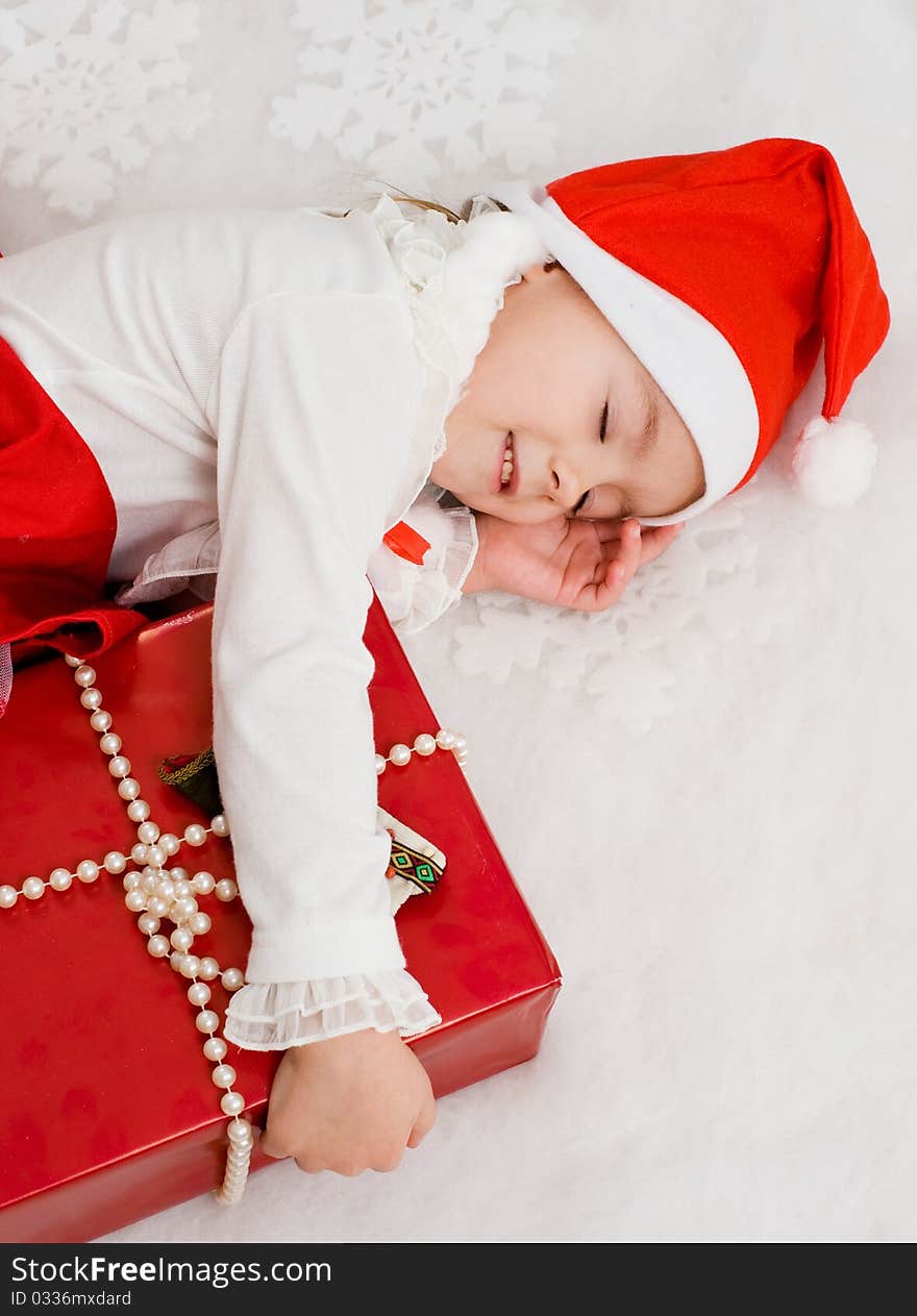 The child sleeps near to a New Year s gift