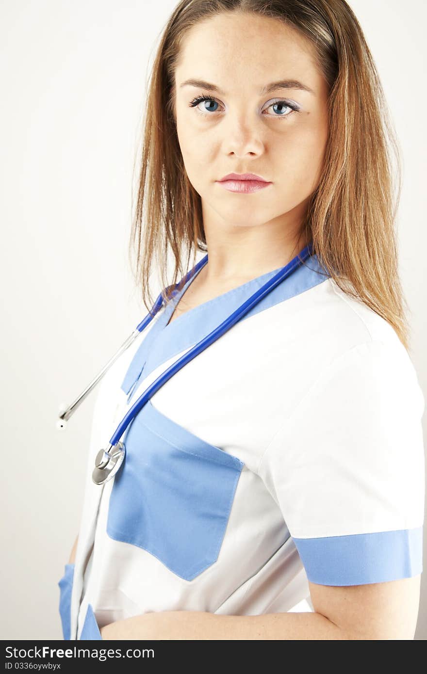 Young woman doctor or nurse holding wearing white and blue scrubs. Young woman doctor or nurse holding wearing white and blue scrubs