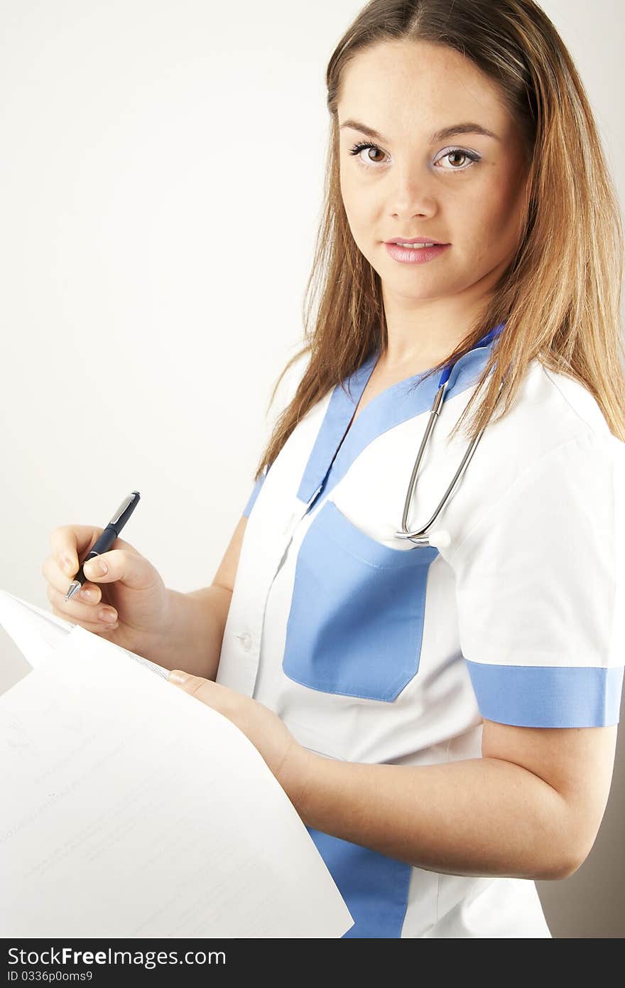 Young woman doctor or nurse holding wearing white and blue scrubs. Young woman doctor or nurse holding wearing white and blue scrubs