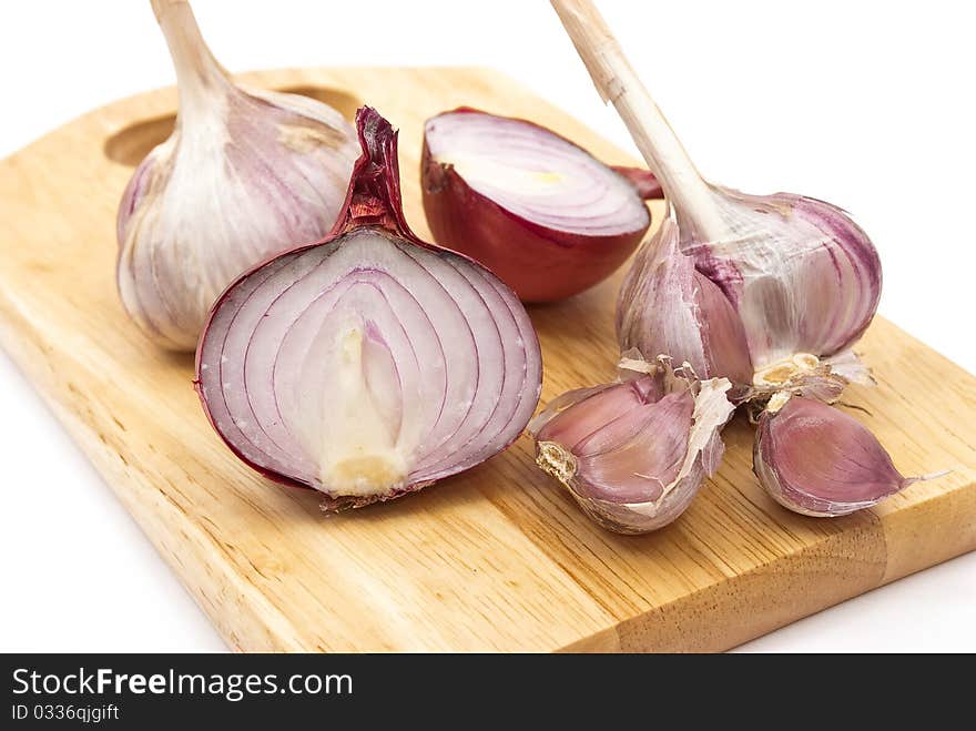 Garlic and onion on a wooden plate