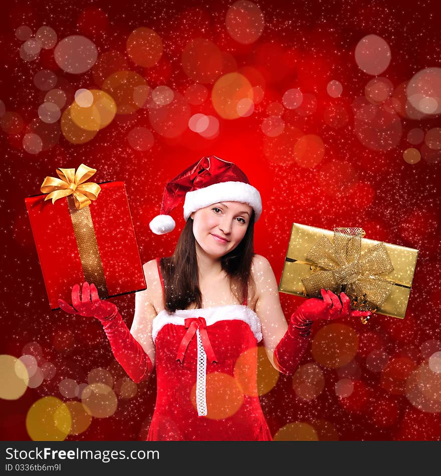 Portrait of a young girl dressed as Santa Claus on a red background. Girl gives gifts. Happy New Year and Merry Christmas!