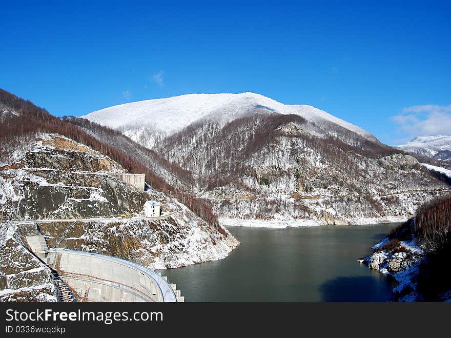 Water dam enclosed by snowy mountains. Water dam enclosed by snowy mountains