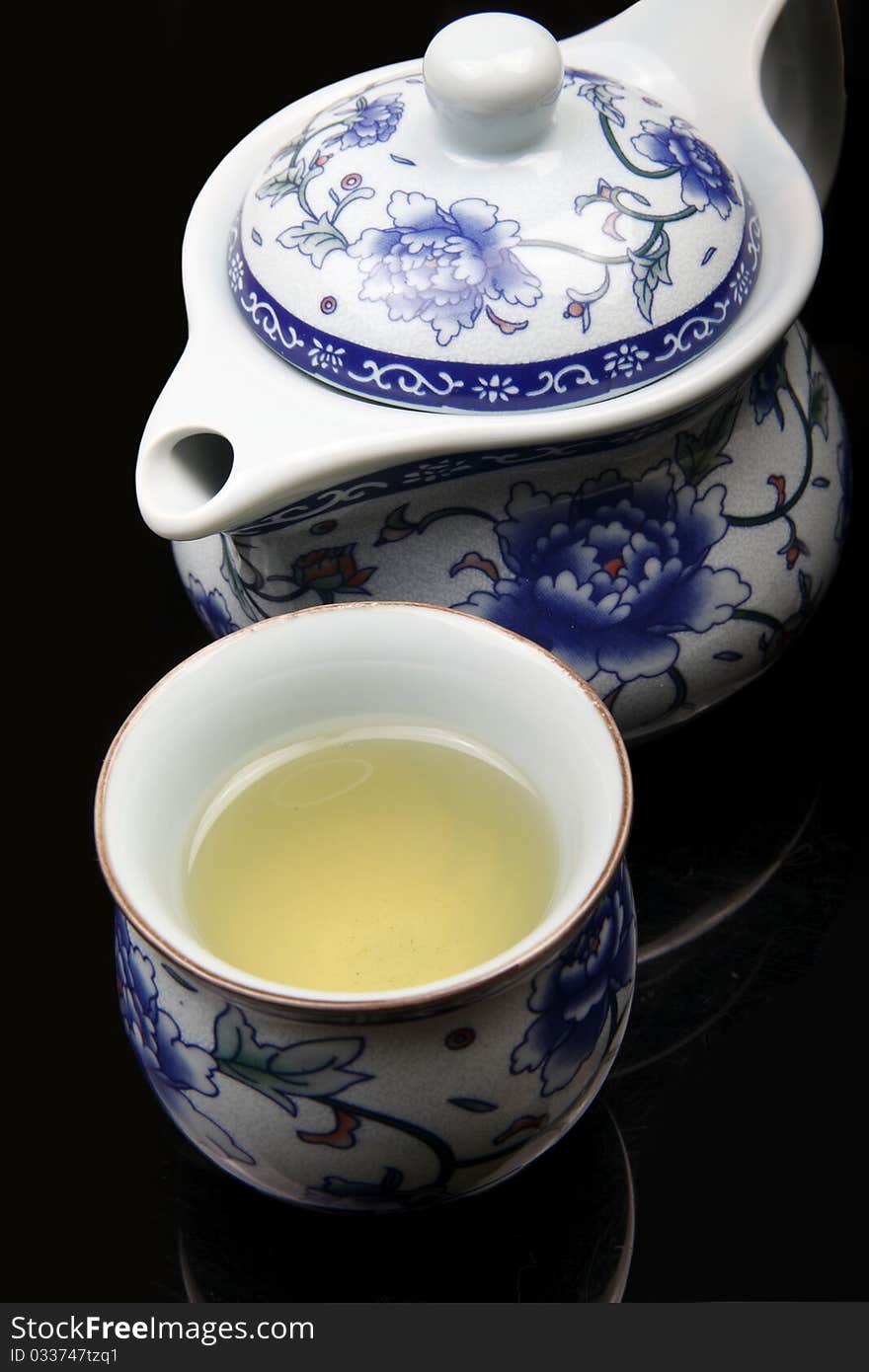 Close up of Chinese tea pot and cup on black background. (Jingdezhen Porcelain). Close up of Chinese tea pot and cup on black background. (Jingdezhen Porcelain)