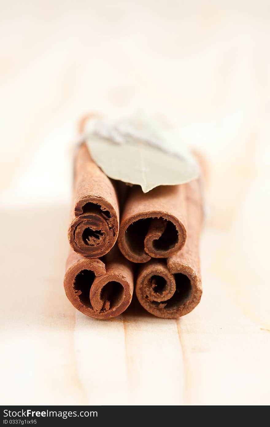 Group of cinnamon sticks and bay-leaf on kitchen wooden board