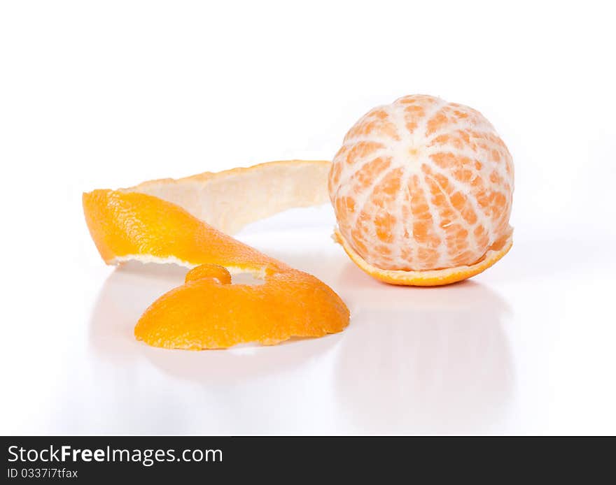 A macro angled front view of a peeled clementine with its peel and shadow on a white background. A macro angled front view of a peeled clementine with its peel and shadow on a white background.