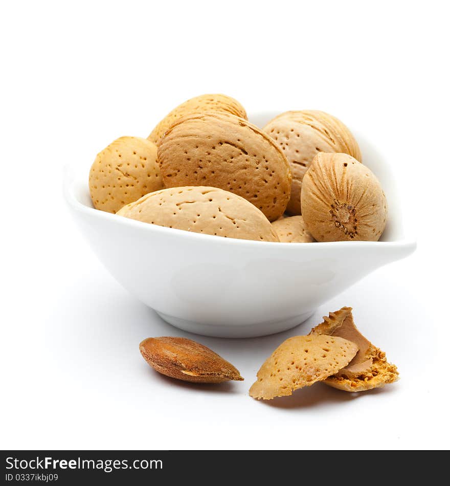 Fresh almonds in a bowl isolated on white background