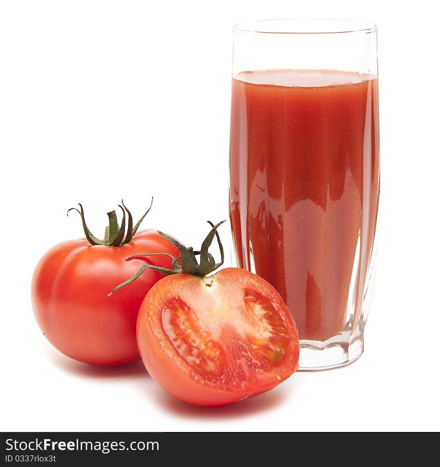 Fresh tomatoes and a glass full of tomato juice on white