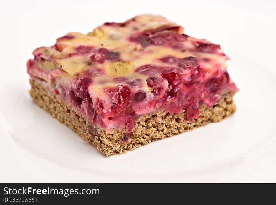 One piece of a delicious red currant cake served on a white plate. One piece of a delicious red currant cake served on a white plate