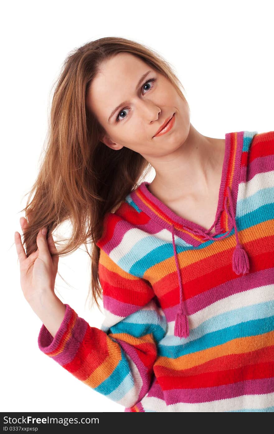 Bright young woman plays with her long hair standing in colorful blouse on white background