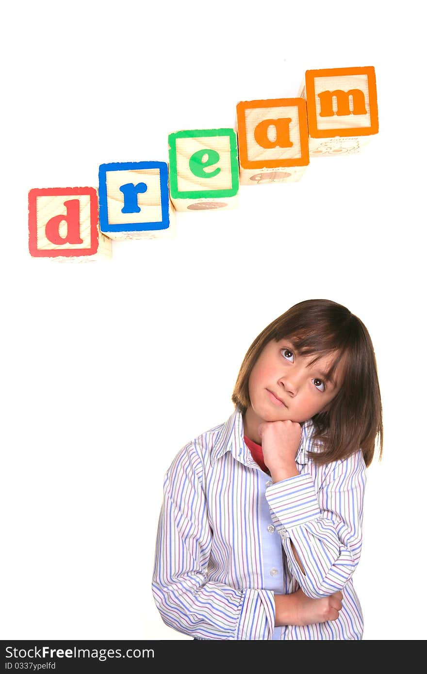 A young girl in a dreaming posture with the word dream above in blocks. A young girl in a dreaming posture with the word dream above in blocks.