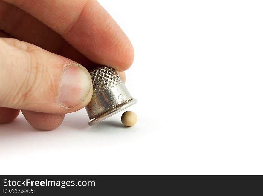 Thimble and pea isolated on white background