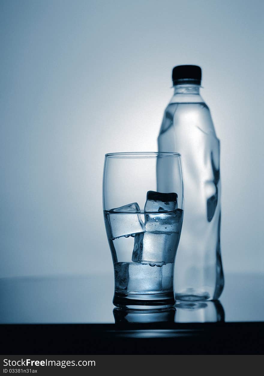 Glass of cold mineral water with ice and plastic bottle. scanned from 6x7 film