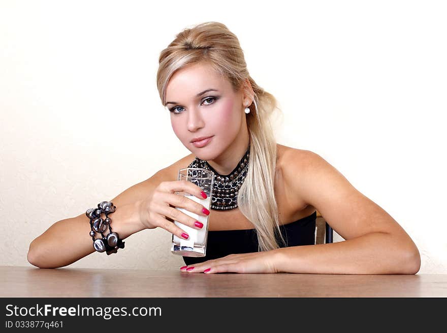 Woman with glass of milk against yellow wall at table