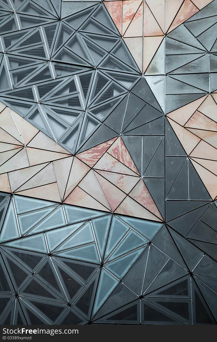 Mixed sandstone, zinc and glass panels of interlocking triangles. Mixed sandstone, zinc and glass panels of interlocking triangles