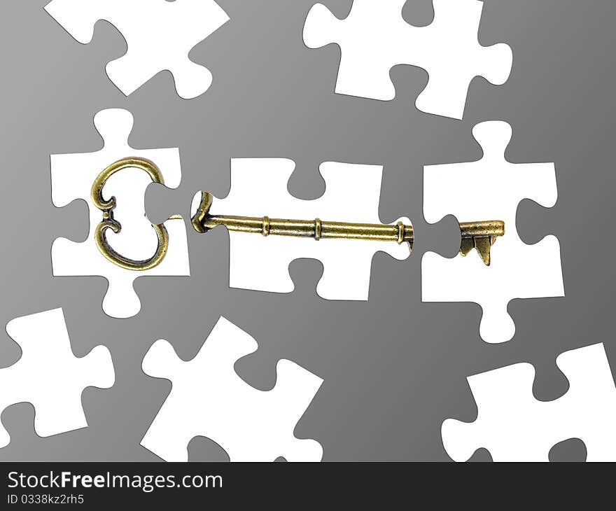 Jigsaw puzzle pieces of a key isolated against a grey background. Jigsaw puzzle pieces of a key isolated against a grey background