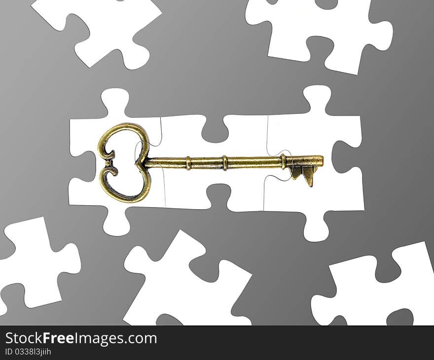 Jigsaw puzzle pieces of a key isolated against a grey background. Jigsaw puzzle pieces of a key isolated against a grey background