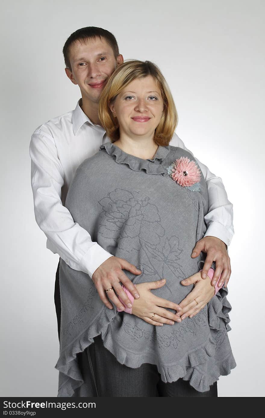 The man embraces the pregnant woman