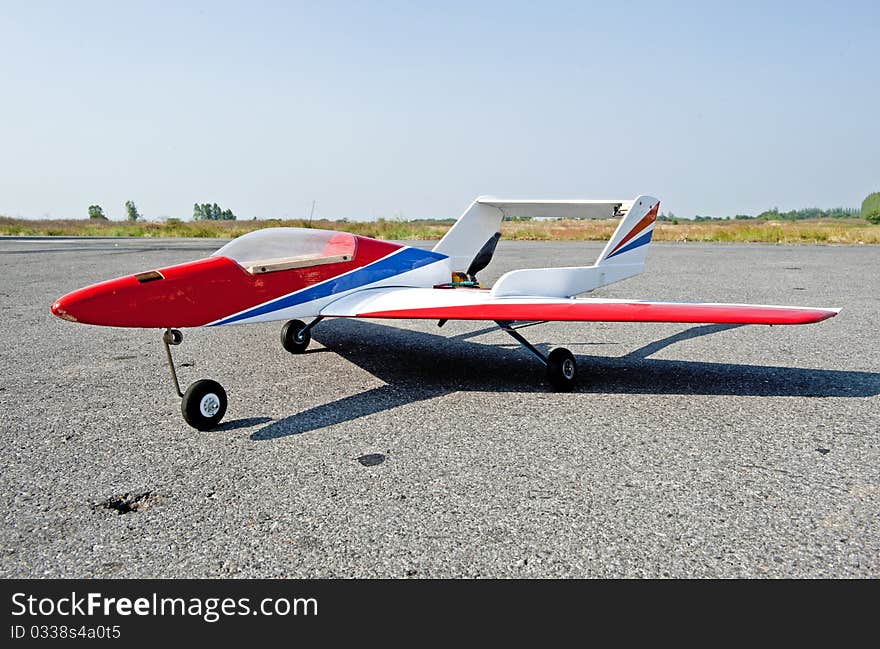 Homemade radio control toy aircraft with electric motor on runway.