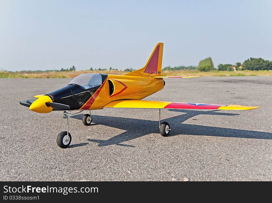 Homemade radio control toy aircraft with electric motor on runway.