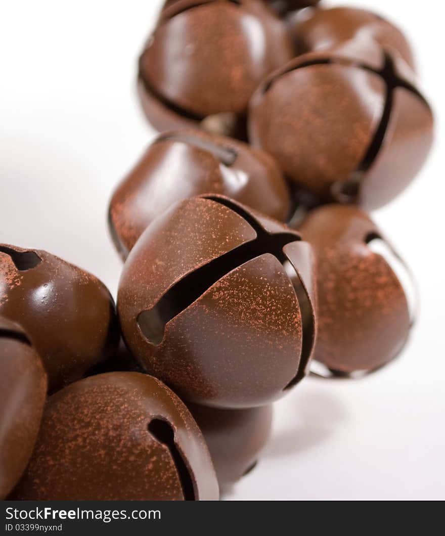 Closeup of vintage copper sleigh bells isolated on white, shallow depth of field with focus on foreground bells. Closeup of vintage copper sleigh bells isolated on white, shallow depth of field with focus on foreground bells