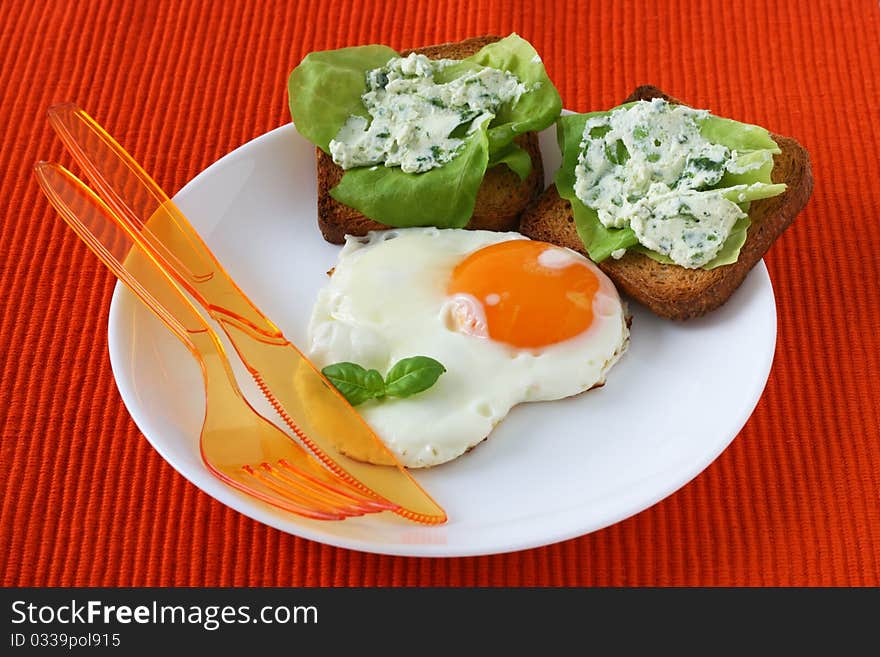 Fried egg with toasts with cream cheese and salad