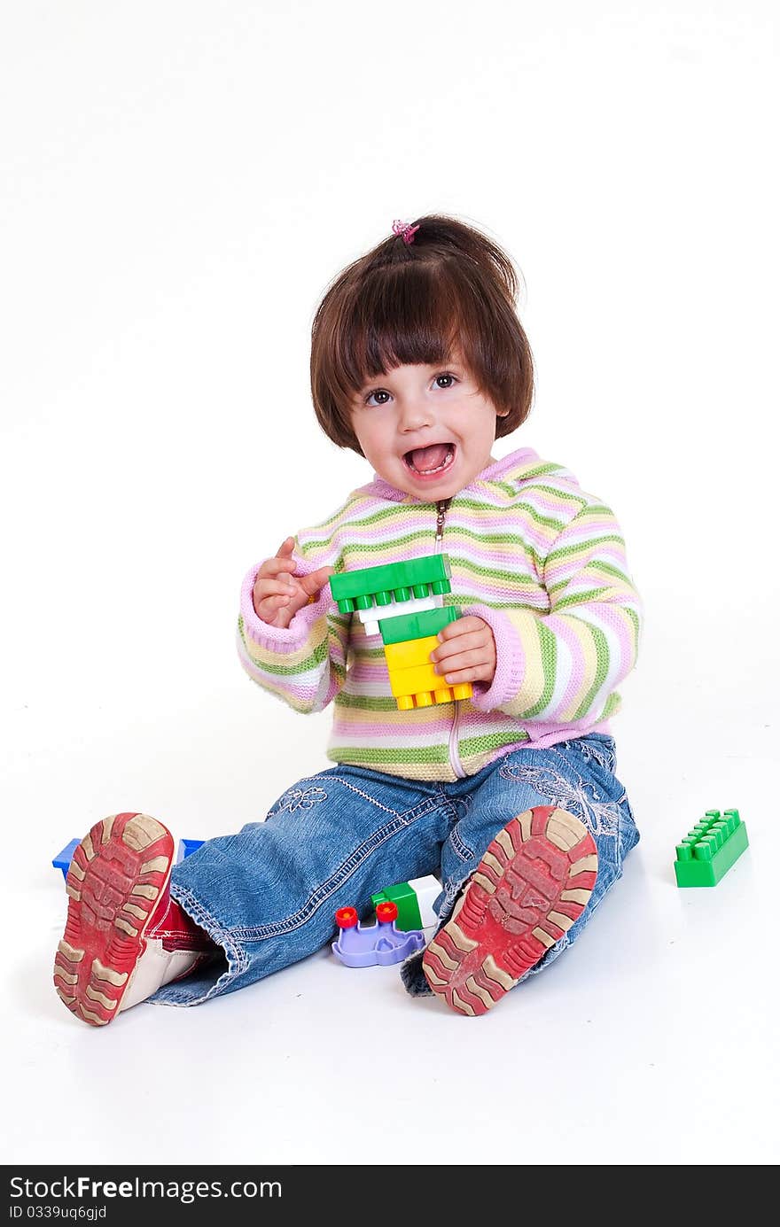 Cute little girl is constructing using building blocks