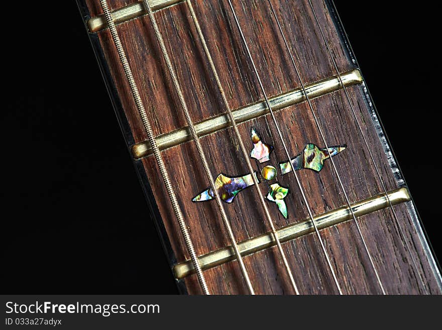 A nice inlay on an electric guitar against a black background. A nice inlay on an electric guitar against a black background