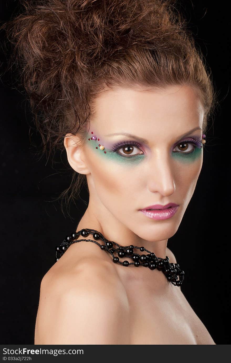 Portrait of young woman with creative make-up on black